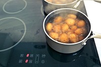 Potatoes boiling in the pots on multi zone induction hob