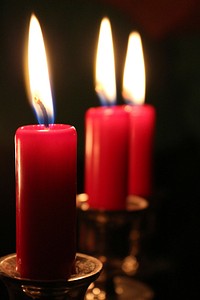 Burning red candles in the dark. Free public domain CC0 image.