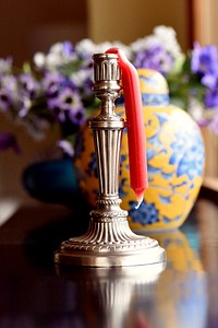 Melted red candle on holder. Free public domain CC0 photo.