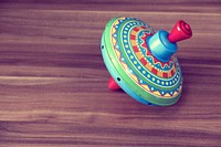 Close up of colorful metal spinning top on wooden table. Free public domain CC0 photo.