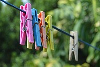 Close up of plastic clothespins hanging to clothesline. Free public domain CC0 photo.