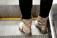 Person standing on escalator. Free public domain CC0 photo.