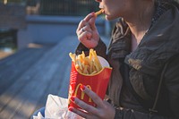Girl eating French fries, McDonald's, location unknown, date unknown