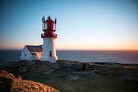 Lighthouse on a cliff near seashore. Free public domain CC0 photo.