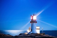 Lighthouse on a cliff near seashore. Free public domain CC0 photo.