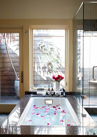 Inside view of hotel bathroom with bathtub and glass windows, free public domain CC0 image.