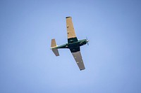 View of light aircraft flying in clear blue sky