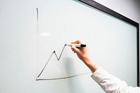 Close up of male hand drawing a diagram on whiteboard in office