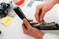 Close up of unrecognizable person hands with pins and stapler in office