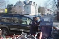 Close up of trash cart with blur view of beggar in the background