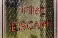 Free close up of fire escape written on the glass pane of a door image, public domain CC0 photo.