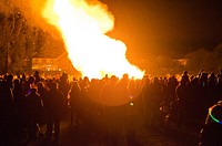 Burning campfire surrounded by people. Free public domain CC0 photo.