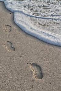 Footsteps print on beach sand. Free public domain CC0 image.
