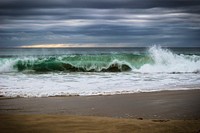 Sea waves crashing onto sand. Free public domain CC0 photo.