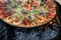 Paella cooking over charcoal. Free public domain CC0 photo.