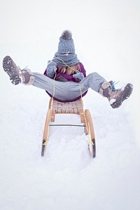 Girl on a sleigh in winter. Free public domain CC0 photo.