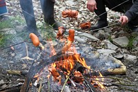 Grilling sausage over bonfire. Free public domain CC0 photo.