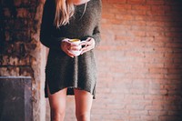 Free woman stands and hold white cup image, public domain people CC0 photo.