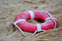 Life buoy on beach sand. Free public domain CC0 image.