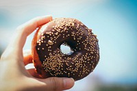 Free hand holding chocolate donut image, public domain food CC0 photo.