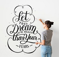 Female artist writing a life motivation quote on the wall