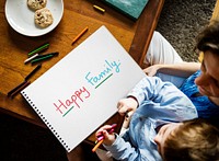 Kid writing Happy Family on a paper