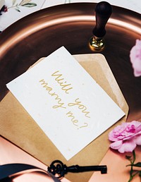 Feminine flat lay of a marriage proposal card