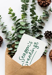 Card in an envelope mockup with leaves in the background