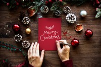 Woman writing Merry Christmas on a card