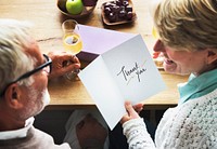 Mature couple holding a thank you card