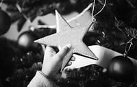 Little kid holding a Christmas tree star ornament