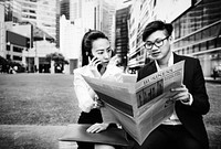 Asian business people reading the newspaper