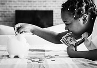 African girl collecting money in a piggy bank