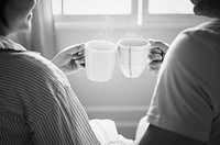 Happy couple celebrating with cups of coffee