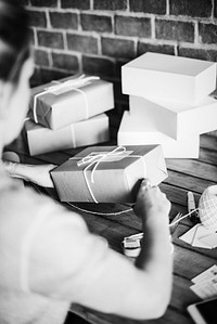 Woman wrapping a package by herself