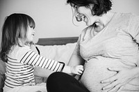 Pregnant mom spending time together with her daughter