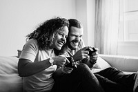 Couple playing video games at home