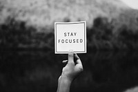 Hand holding stay focused text
