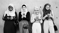 Muslim girls using smartphones in a row