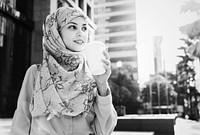 Muslim woman drinking coffee in the city