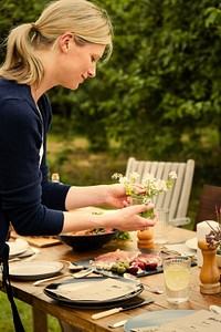 Woman preparing the table for a dinner in the garden