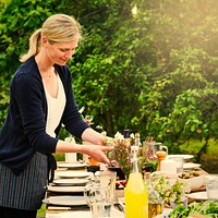 Woman preparing the table for a dinner in the garden