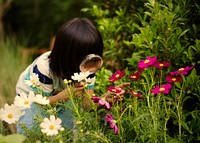 Little girl observing some flowers