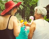 Senior friends having a cocktail by the pool