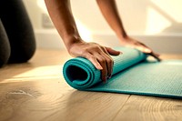Woman rolling up a yoga mat