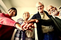Elderly group of friends stacking hands