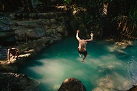 Man jumping into a natural pond