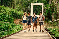 Friends walking on a bridge through the forest