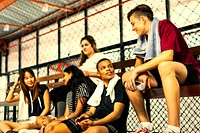 Teenage friends hanging out at a bsaketball court