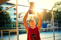 Teenage basketball player holding up a trophy